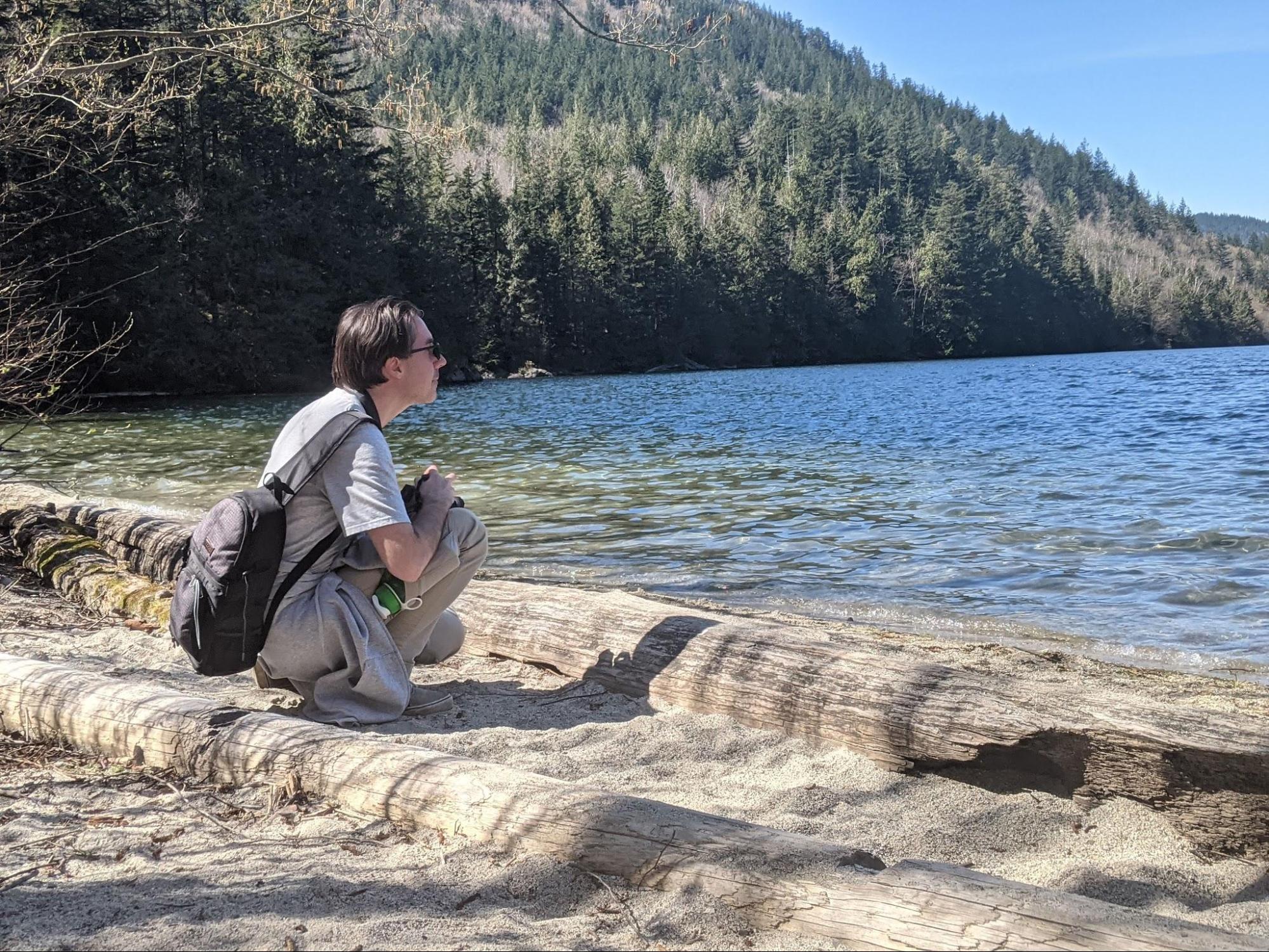 Jay sitting on the small beach at the south end of Hicks Lake in Sasquatch Provincial Park, BC, Canada