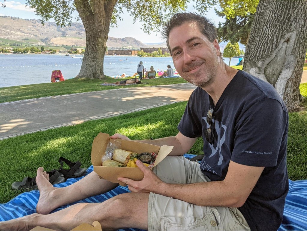 Jay enjoying a Mexican burrito lunch in the park at Osoyoos Lake in Osoyoos, BC. 