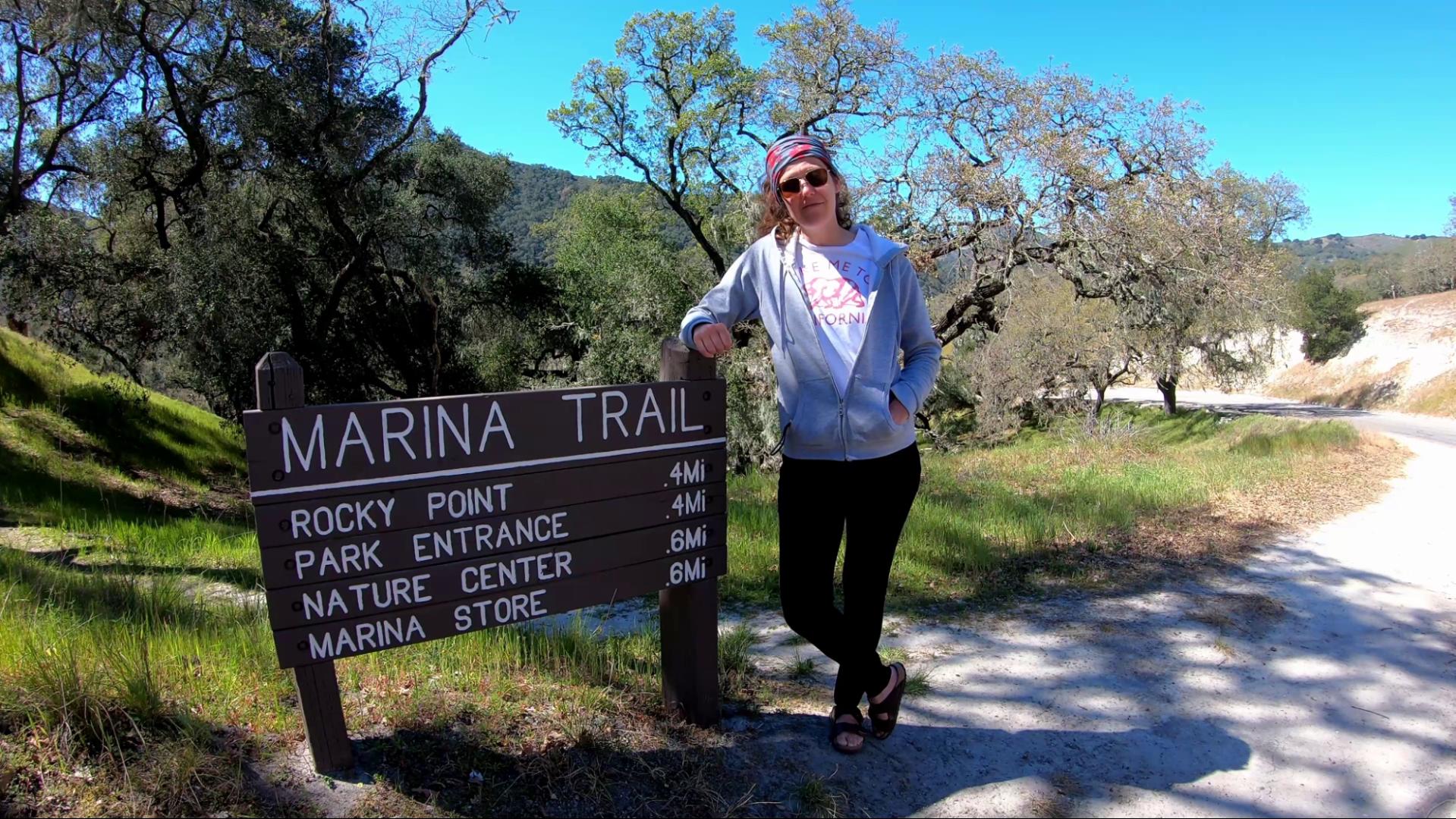 Mel standing next to one of the hiking trail signs at Lopez Lake. 
